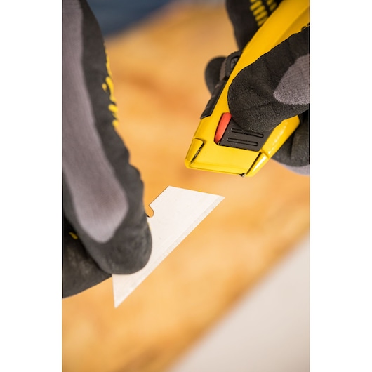 Photo of STANLEY 0-10-778 utility knife being loaded with a blade, gloved hands visible.