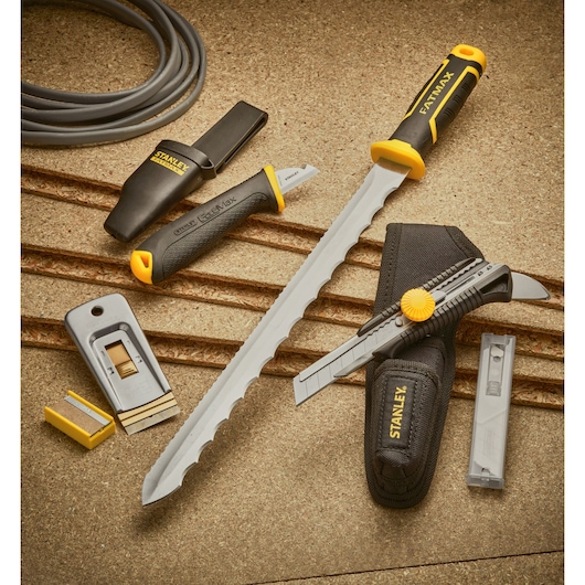 STANLEY 0-28-500 set of hand tools with cutting knives, a rasp, utility blades, and black-yellow handles on a tan surface.