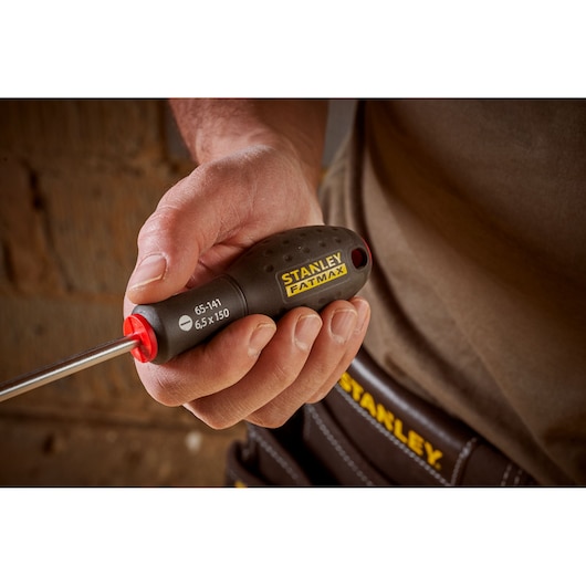 Photo of STANLEY 0-65-141 screwdriver with black and yellow handle, held in hand, close-up view.