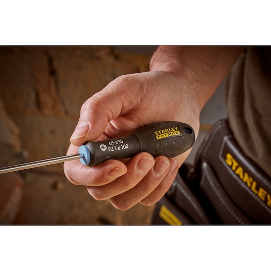 Photo of STANLEY 0-65-335 screwdriver with black ergonomic handle and yellow branding held in hand.