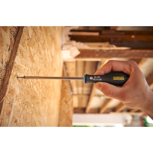 STANLEY 0-65-337 screwdriver being used to drive a screw into wooden panel, close-up hand photography.