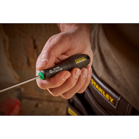 Photo of STANLEY 0-65-396 screwdriver with black and yellow handle held in hand, tool pouch in background.