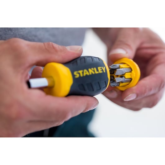 STANLEY 0-66-357 multi-bit screwdriver with yellow and black handle, close-up, showing bit storage in cap.