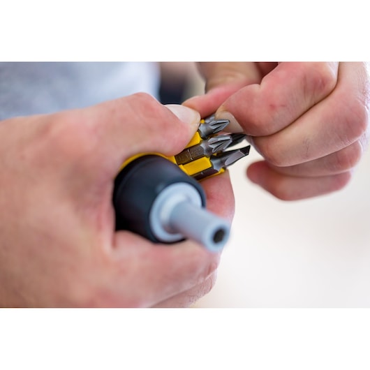 Photo of STANLEY 0-66-358 screwdriver with interchangeable bits held in hand, close-up view.