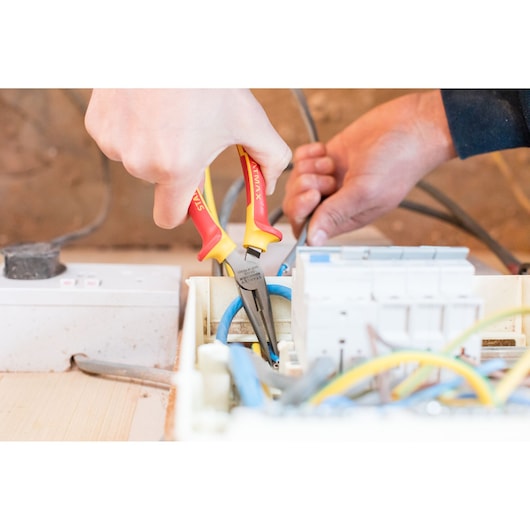 Photo of STANLEY 0-84-006 insulated pliers being used on electrical wiring in a control panel.