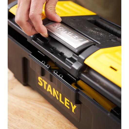 Photo of STANLEY 1-79-216 tool box being opened, black and yellow plastic, close-up angle.