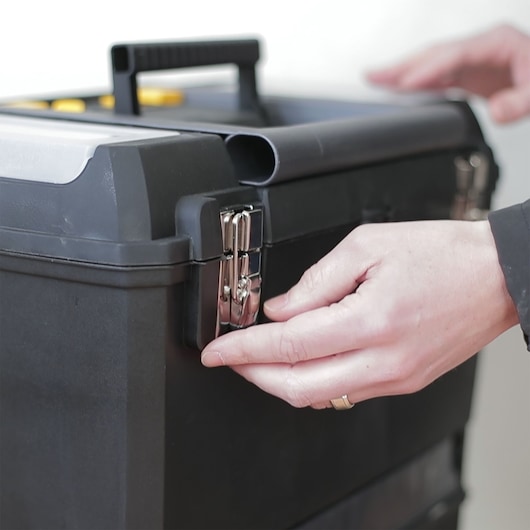 STANLEY 1-93-968 black toolbox with silver latch being opened, close-up photo of product in use.