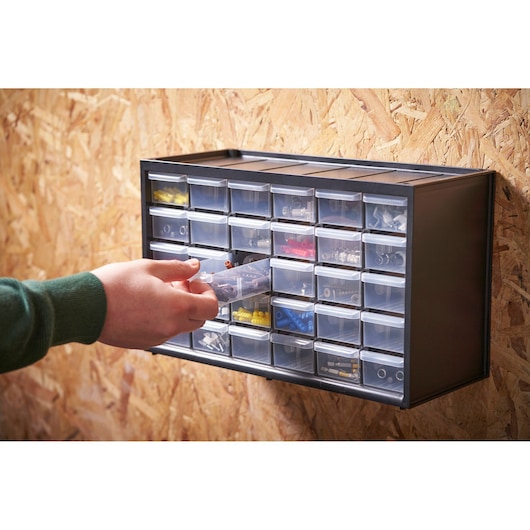 STANLEY 1-93-980 organizer with transparent drawers mounted on wall, hand accessing contents.