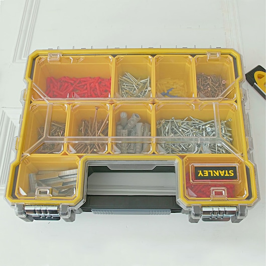 STANLEY 1-97-518 organizer box with transparent lid, yellow dividers, and assorted screws and anchors, top view.