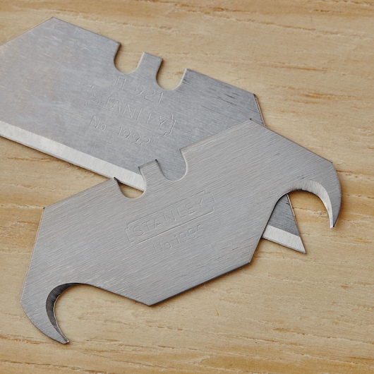 STANLEY 10-099 utility hook blades, close-up on flat wooden surface.
