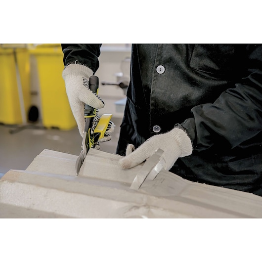 Photo of STANLEY 14-563 aviation snips in use, person cutting material, wearing gloves and dark jacket.