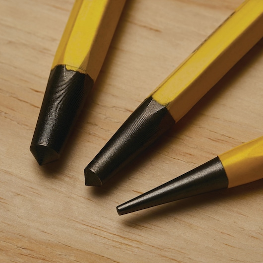 STANLEY 16-299 set of three yellow and black steel punches on wood surface, close-up photography.