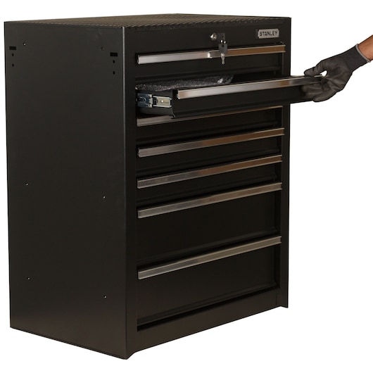 STANLEY 93-547-23ID black metal tool chest with seven drawers, side angle, one drawer partially open, gloved hand visible.
