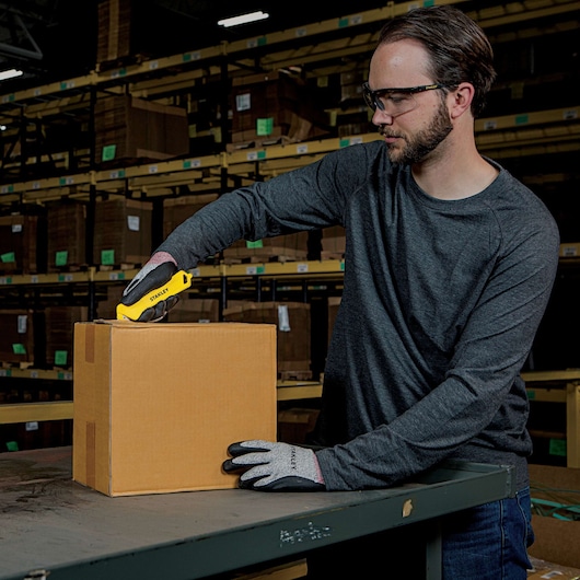 Single Sided Pull Cutter being used for opening cardboard box by person.