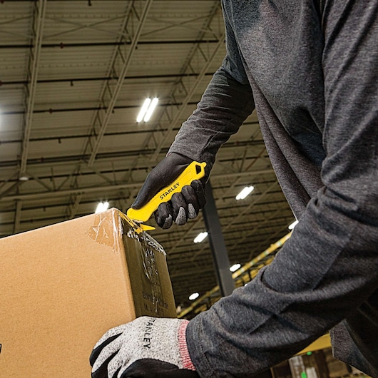 Single Sided Pull Cutter being used for cutting cello tape on cardboard box.