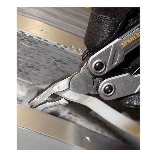 STANLEY FMHT0-72414 multitool pliers gripping a white cable, close-up photo.
