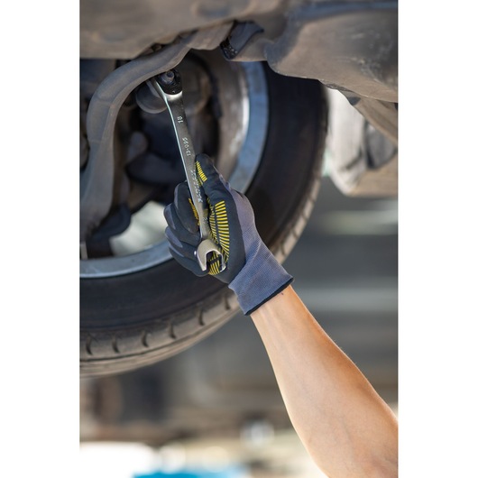 Photo of STANLEY FMMT13084-0 wrench used by a gloved hand tightening a nut under a car near the tire.