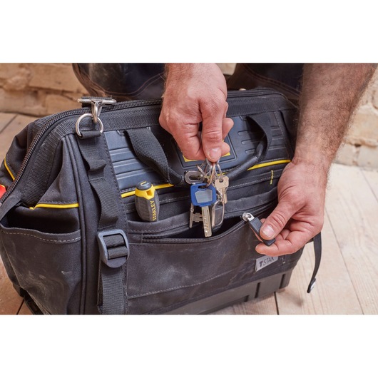 STANLEY FMST83297-1 tool bag, front angle, black with yellow accents, keys and screwdriver in pocket.