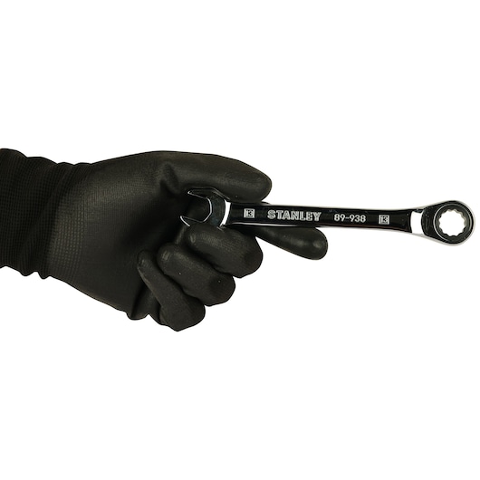 Photo of STANLEY STMT89938-8B combination wrench held in a black-gloved hand, front view.