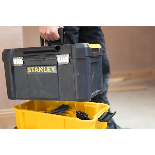 STANLEY STST1-80151 black toolbox with yellow accents, carried by hand, photography product category.