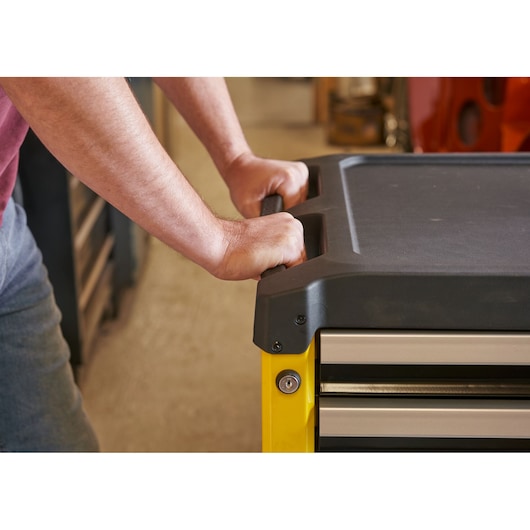 STANLEY STST74305-1 tool chest handle in use, close-up, black top, yellow frame, drawer visible.