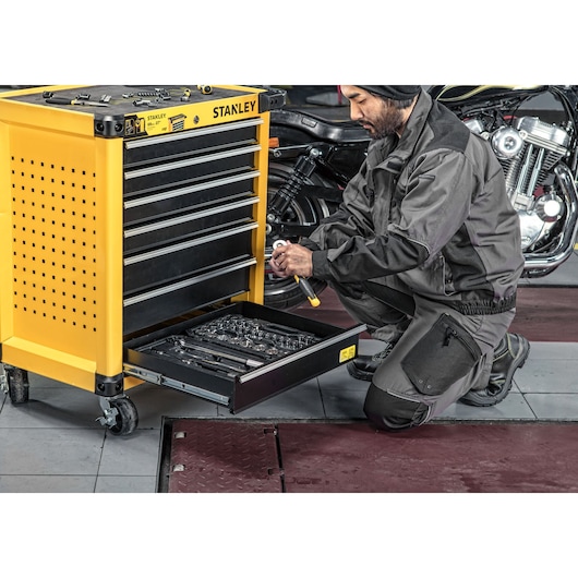 Close-up of Man taking out a hand tool from bottom drawer of 7 drawers metal roller cabinet